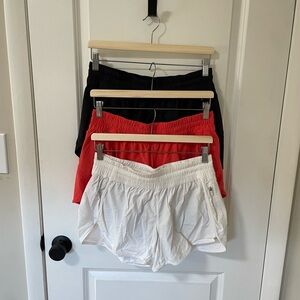 Bundle lululemon Track That Mid-Rise 5” shorts. Size 12. Black, red, white.